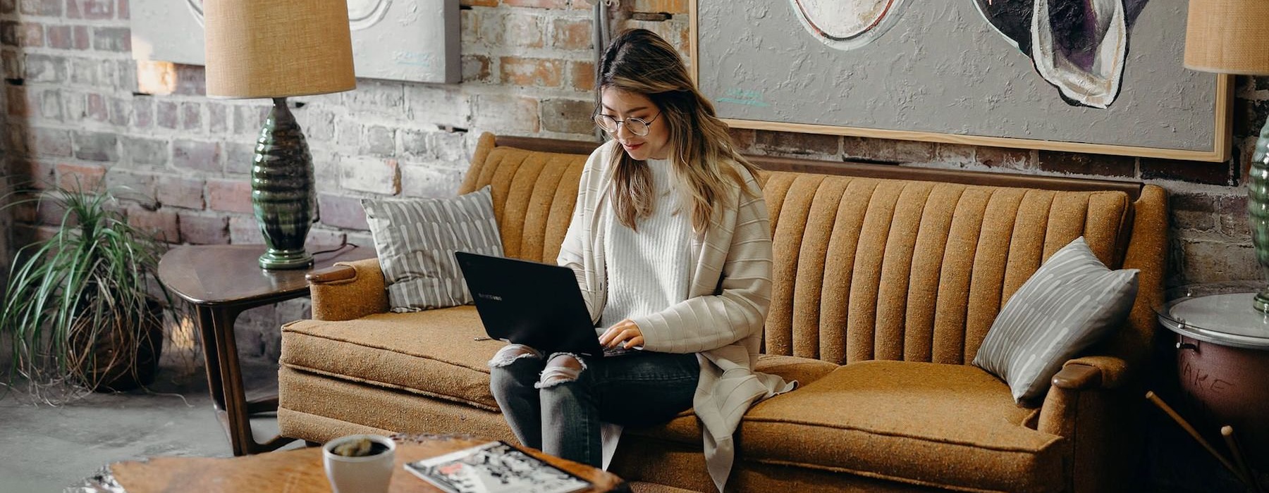 a woman sitting on a couch and typing